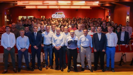 Grupo de empleados en un auditorio con el logotipo ELPOZO visible en la pared posterior.