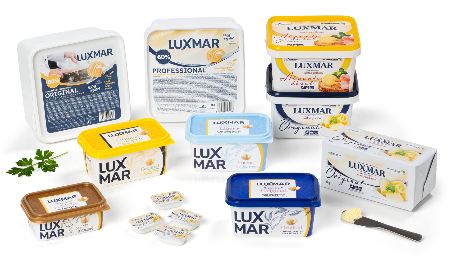 Envases de mantequilla y margarina LUXMAR en distintos formatos sobre fondo blanco, con cucharilla y porciones.