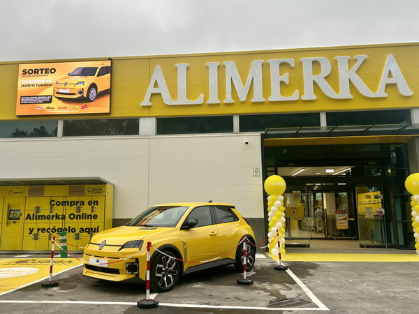 Coche promocional amarillo aparcado frente a la fachada de ALIMERKA con columnas de globos y señalética de recogida online.