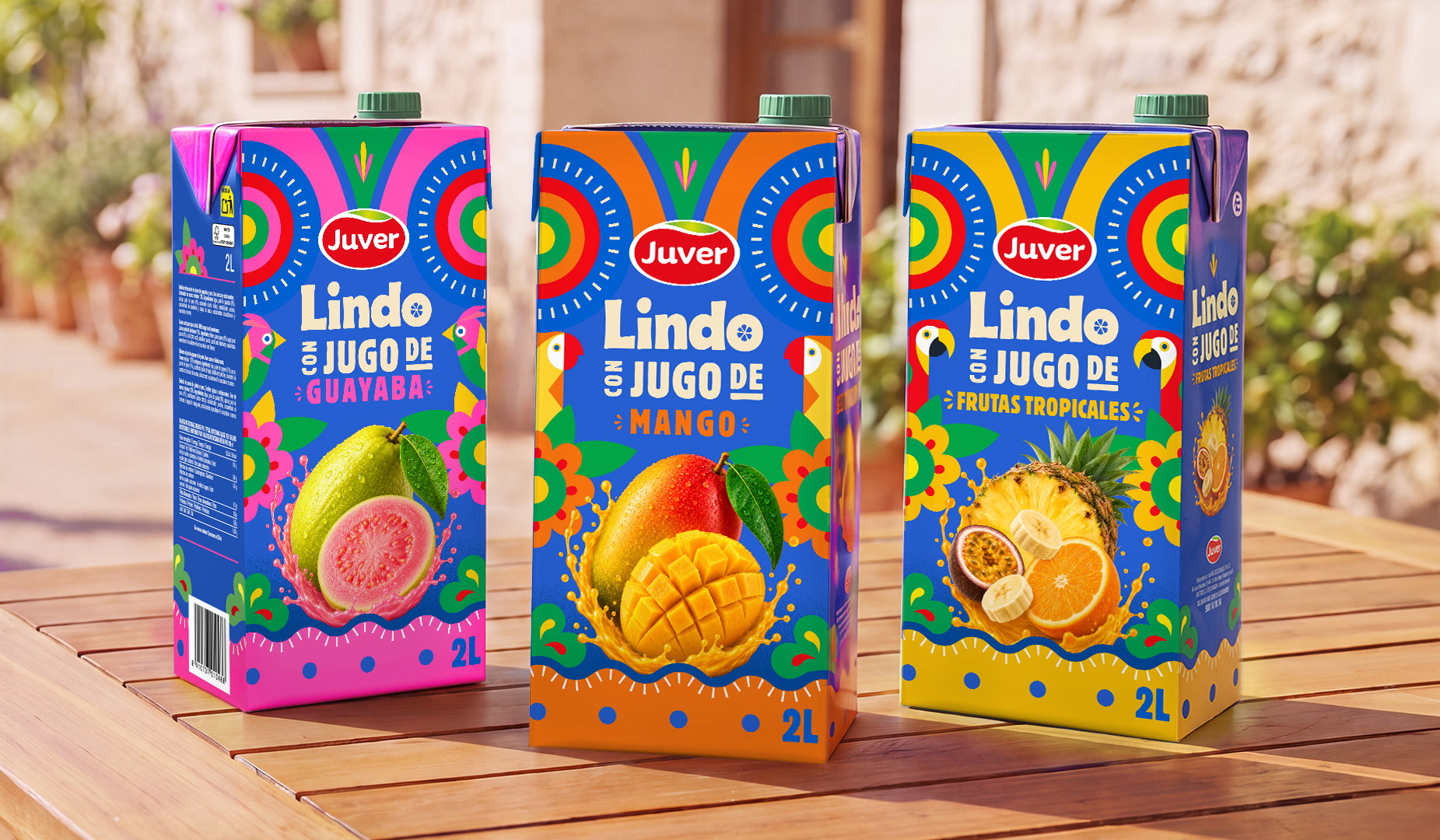 Cartones de zumo Juver Lindo 2L de mango, guayaba y frutas tropicales sobre mesa de madera.