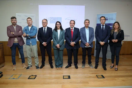 Ocho directivos posan en fila en un escenario con la proyección USC y Lactalis y dos rollups laterales.